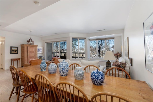 dining room with light wood-style floors and visible vents