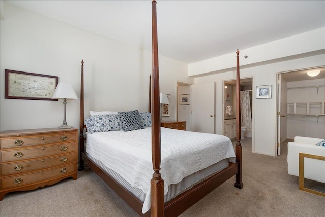 bedroom with light colored carpet and connected bathroom