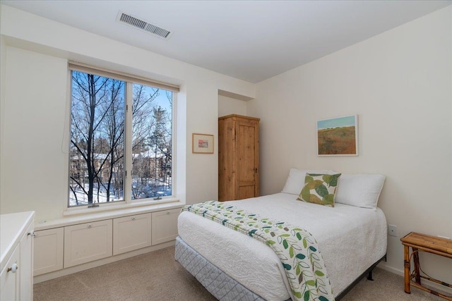 bedroom featuring visible vents and light carpet