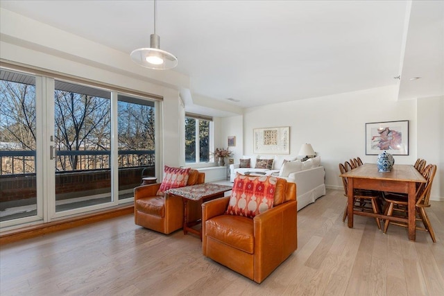 living area featuring baseboards and light wood finished floors