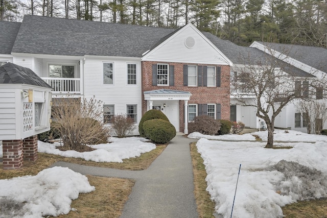 view of front of property with aphalt driveway, brick siding, and roof with shingles