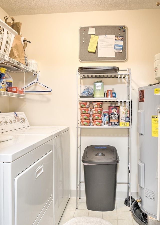 laundry area with washer and dryer, a textured ceiling, electric water heater, light tile patterned floors, and laundry area