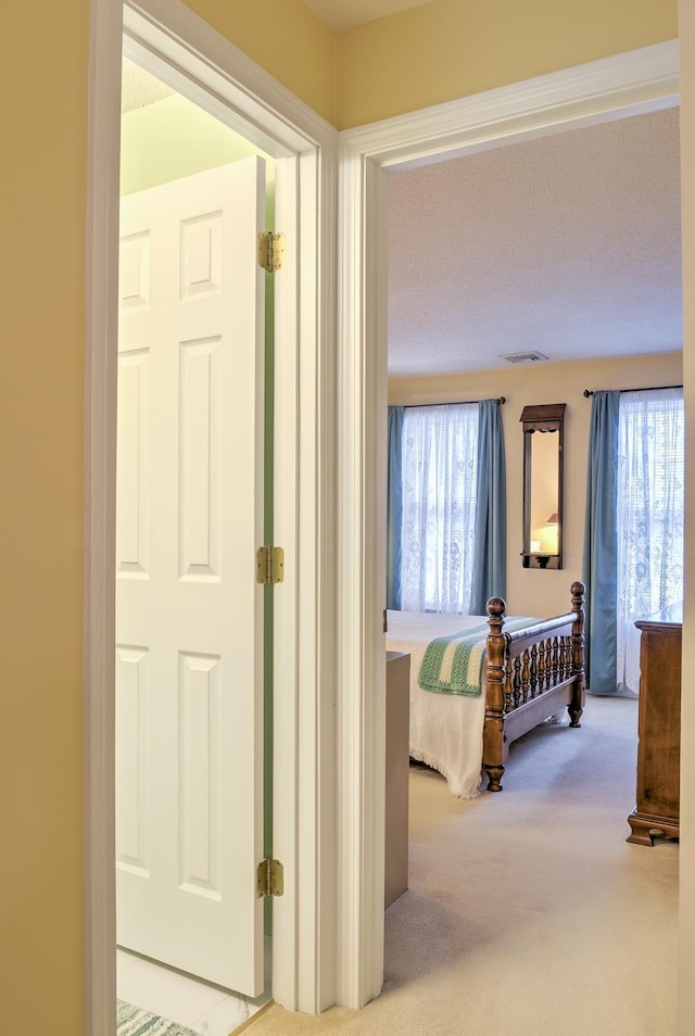 hallway with visible vents and carpet floors