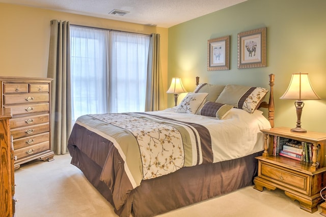 bedroom with light carpet, visible vents, multiple windows, and a textured ceiling