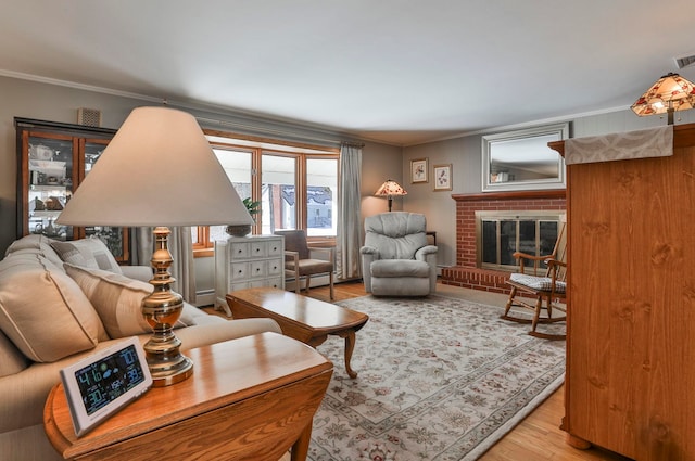 living area with visible vents, wood finished floors, a fireplace, and ornamental molding