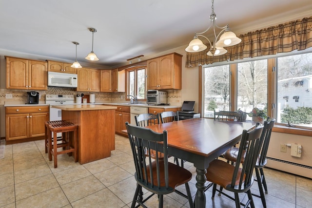 dining space featuring light tile patterned floors, a notable chandelier, baseboard heating, and ornamental molding