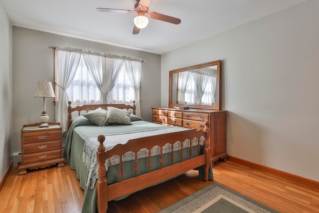 bedroom featuring light wood-type flooring, baseboards, and ceiling fan