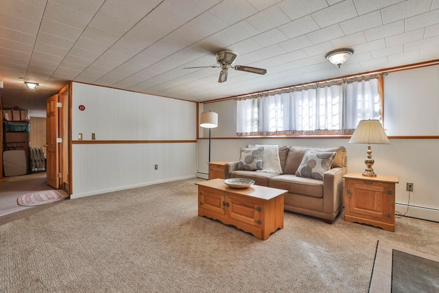 living area featuring light colored carpet, a baseboard heating unit, and ceiling fan