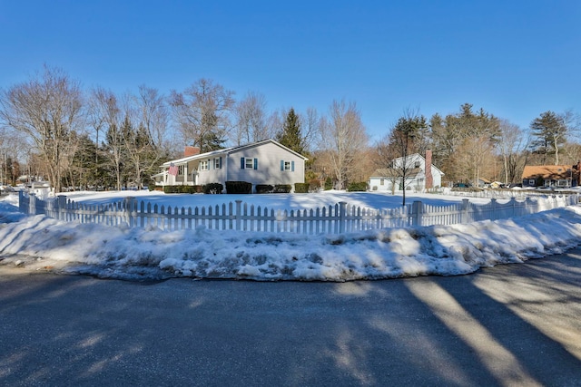 snow covered pool featuring a fenced front yard