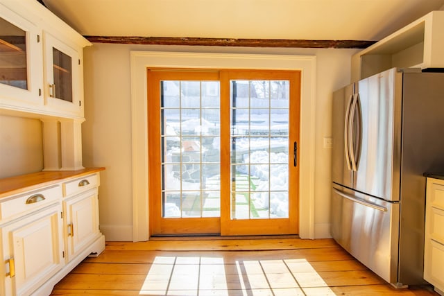 doorway featuring light wood-type flooring and baseboards