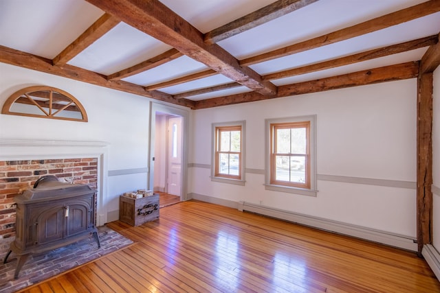 living room with beamed ceiling, hardwood / wood-style floors, baseboards, baseboard heating, and a wood stove