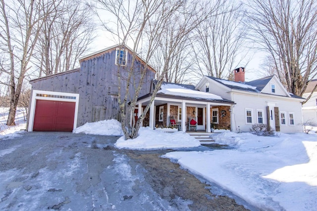 view of front of home with a garage, covered porch, and a chimney