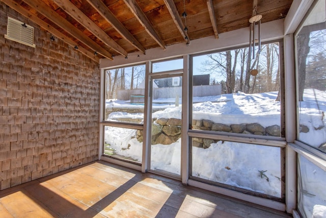 unfurnished sunroom featuring beamed ceiling and wood ceiling