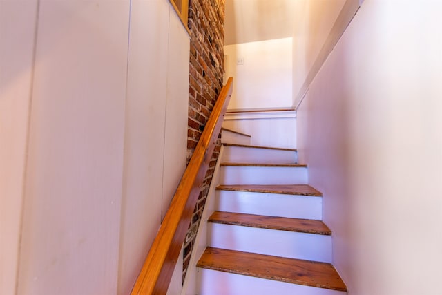 stairs featuring brick wall