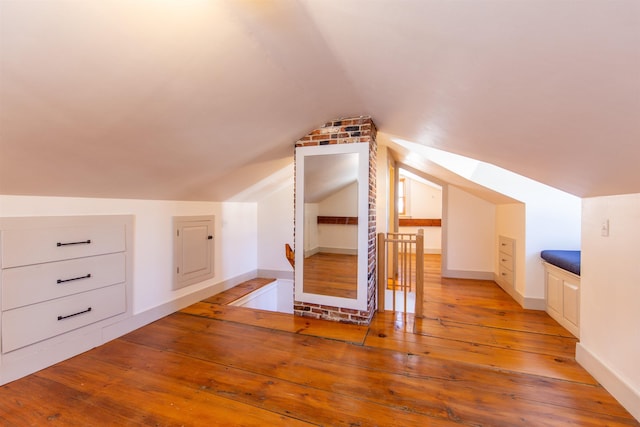 bonus room with vaulted ceiling, baseboards, and light wood-type flooring