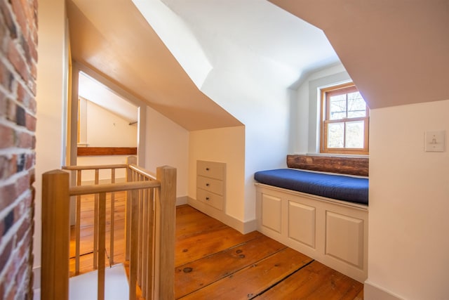 additional living space with vaulted ceiling, light wood-style flooring, and baseboards