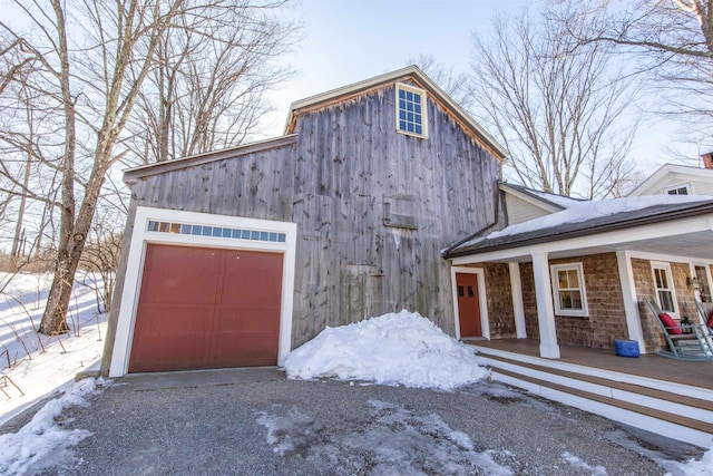 exterior space with a detached garage and covered porch