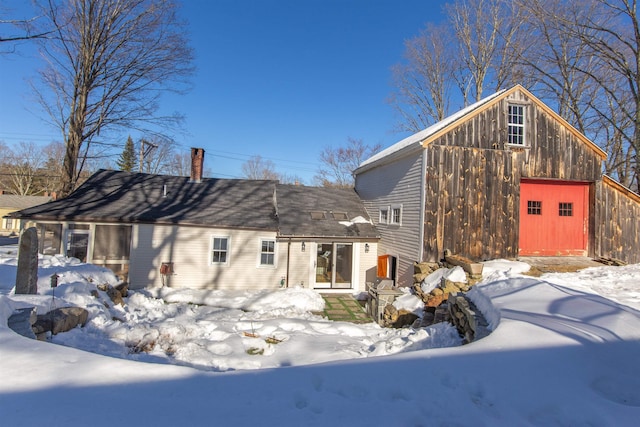 exterior space with an outdoor structure, a garage, and a chimney