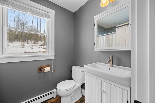 bathroom with a baseboard radiator, baseboards, toilet, and vanity