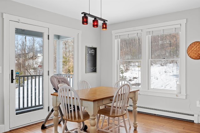 dining space featuring plenty of natural light, wood finished floors, and a baseboard radiator