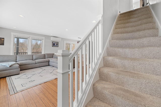 staircase featuring recessed lighting, baseboards, hardwood / wood-style floors, and a wall unit AC