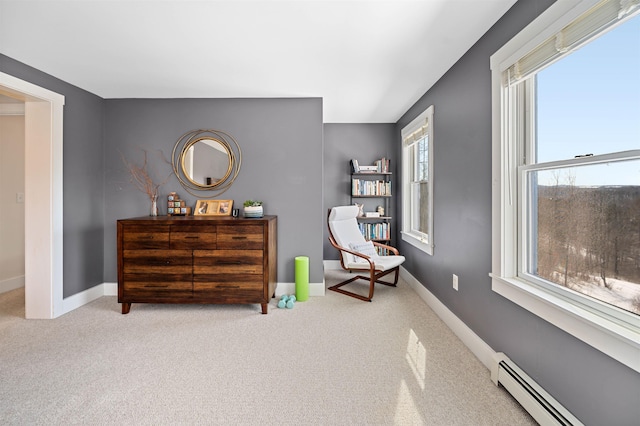 sitting room featuring a baseboard heating unit, carpet flooring, and baseboards