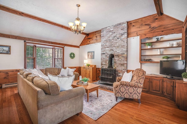 living area with a wood stove, a textured ceiling, light wood-style flooring, and vaulted ceiling with beams