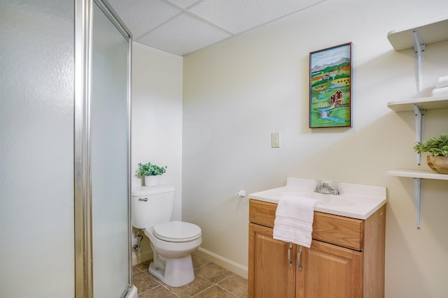 full bath featuring tile patterned floors, toilet, a stall shower, a paneled ceiling, and vanity