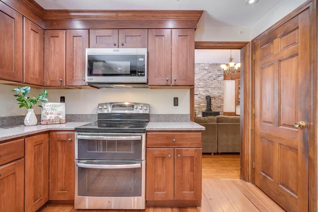 kitchen with light wood finished floors, brown cabinets, and stainless steel appliances