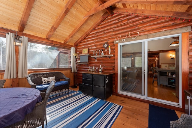 interior space with lofted ceiling with beams, wood ceiling, wood-type flooring, and rustic walls