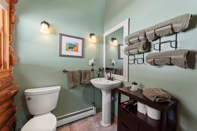 bathroom featuring toilet, baseboard heating, and a sink