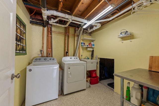 clothes washing area featuring a sink, laundry area, and washing machine and clothes dryer