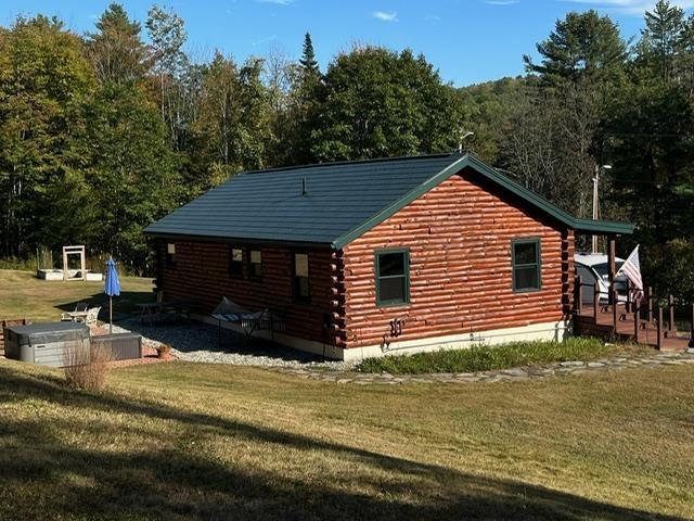 view of home's exterior featuring a lawn and log exterior