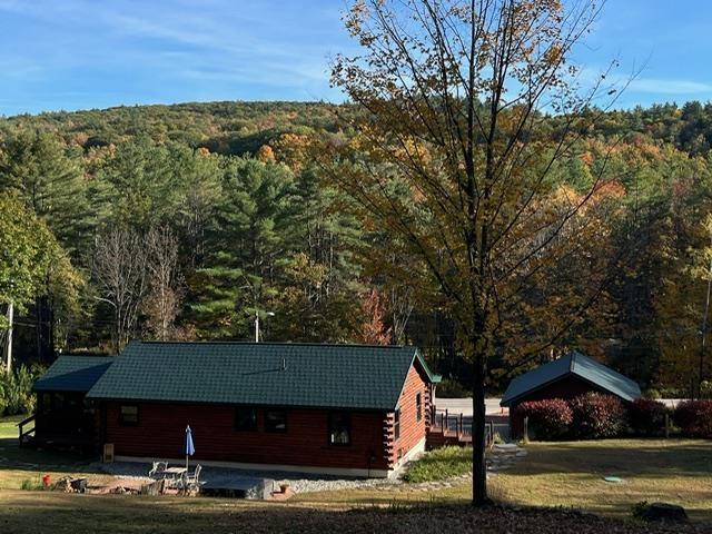 exterior space with log siding and a wooded view