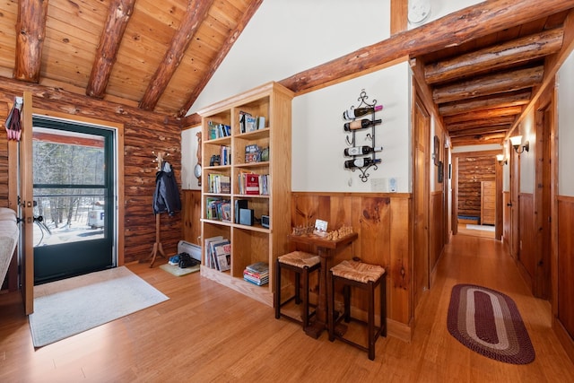 foyer entrance featuring light wood-type flooring, beam ceiling, wood ceiling, and wainscoting