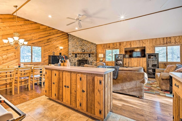 kitchen featuring a wealth of natural light, wood walls, light countertops, and lofted ceiling