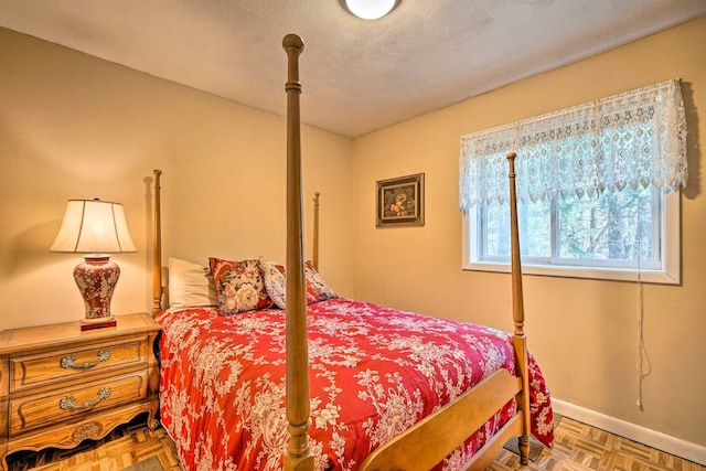 bedroom with baseboards and a textured ceiling