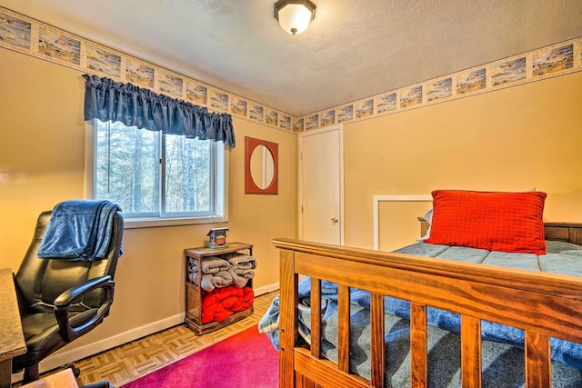 bedroom with baseboards and a textured ceiling