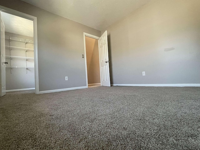 unfurnished bedroom with a closet, baseboards, carpet floors, and a textured ceiling