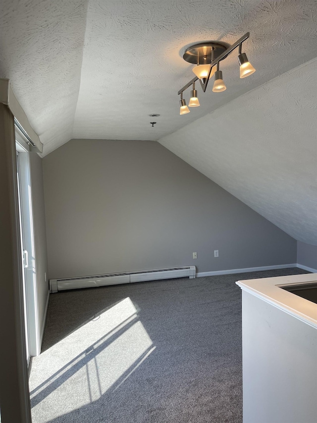 additional living space featuring lofted ceiling, baseboard heating, carpet floors, and a textured ceiling