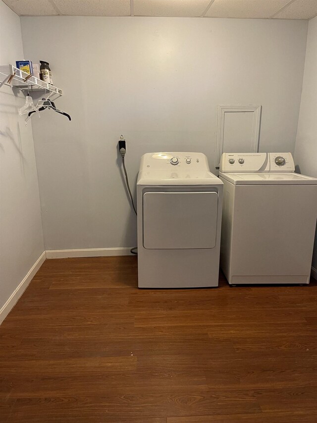 laundry room featuring baseboards, independent washer and dryer, wood finished floors, and laundry area