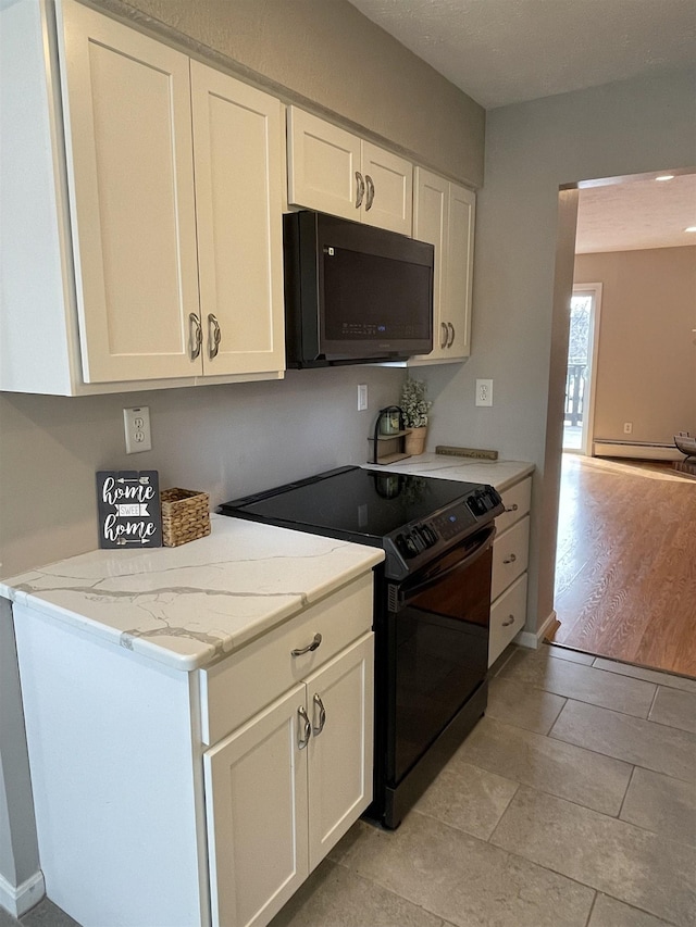 kitchen featuring baseboard heating, white cabinets, black range with electric stovetop, and light stone countertops