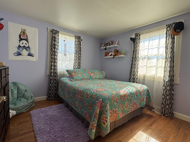 bedroom with baseboards and wood finished floors