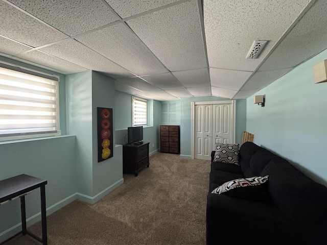 interior space featuring a paneled ceiling, visible vents, carpet floors, and baseboards