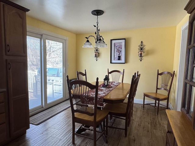 dining space featuring dark wood-type flooring and baseboards