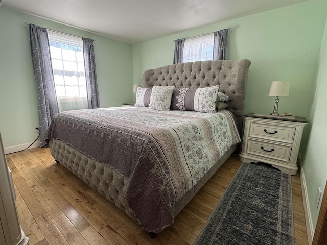 bedroom with baseboards and hardwood / wood-style flooring