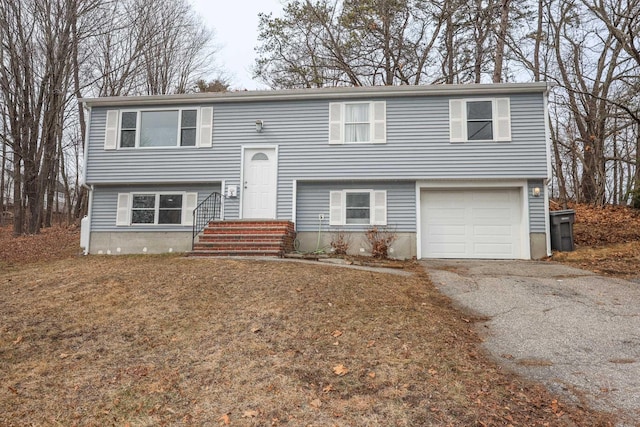 raised ranch featuring a garage and driveway