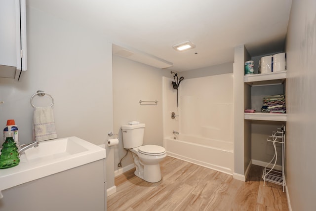 bathroom featuring baseboards, toilet, bathing tub / shower combination, wood finished floors, and vanity