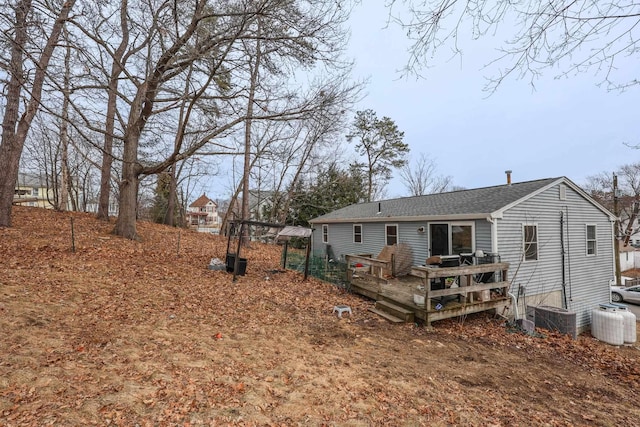 rear view of property featuring central air condition unit and a wooden deck