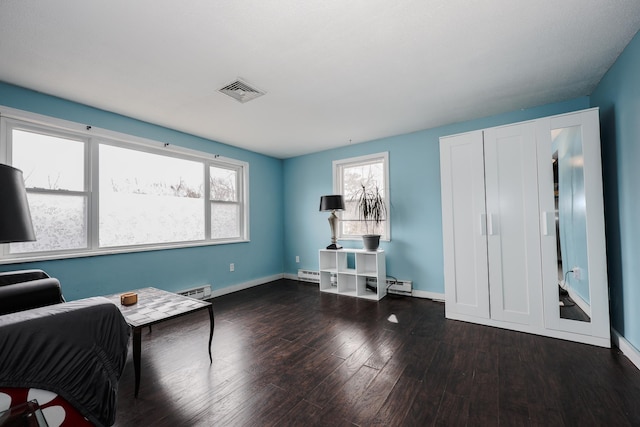 interior space with plenty of natural light, wood finished floors, visible vents, and baseboards